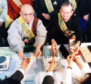 송월주 스님(왼쪽)과 김수환 추기경이 1997년 종교계와 시민소비자단체 대표들과 함께 ‘외채상환 금 모으기 범국민운동’에 나서 시민들이 기탁한 금을 받고있다. 동아일보DB