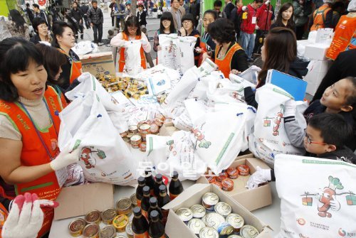 10일 자원봉사자들이 기부된 캔과 고추장 등 음식물을 꾸러미에 넣어 포장하고 있다. 이날 만든 1만 개의 꾸러미는 홀몸노인과 소년소녀가장에게 배달됐다. 김재명 기자 base@donga.com