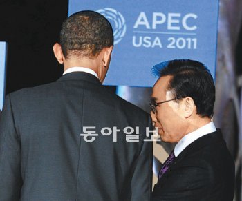 아시아태평양경제협력체(APEC) 정상회의 참석 차 미국 하와이를 방문한 이명박 대통령(오른쪽)이 12일(현지 시간) 호놀룰루 할레코아 호텔에서 열린 ‘정상 및 부인 공식만찬’에서 버락 오바마 미 대통령과 무언가 귀엣말을 나누고 있다. 호놀룰루=청와대 사진기자단