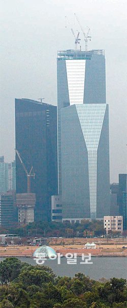 서울 영등포구 여의도동에서 막바지 건설공사 중인 IFC서울을 한강 건너편에서 본 모습. 왼쪽이 콘래드 호텔이고, 오른쪽 앞이 사무용빌딩 1동, 뒤에 타워 크레인이 있는 건물이 최고층인 사무용빌딩 3동이다. 동아일보DB