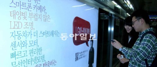 17일 서강대 학생들이 지하철 6호선 대흥역 스크린도어에 설치된 LG이노텍 취업광고를 살펴보고 있다. 스마트폰으로 이 광고 안의 QR코드를 찍으면 이 대학 출신 LG이노텍 직원이 나와 회사생활을 설명해 준다. HS애드 제공