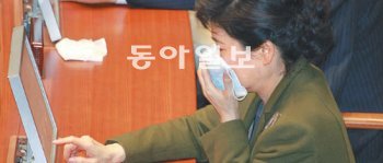 박근혜 전 한나라당 대표가 22일 국회 본회의장에서 최루탄 가루를 막기 위해 손수건으로 입을 가린 채 표결하고 있다. 박영대 기자 sannae@donga.com