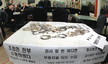 25일 오후 충북 청원군 강내면 충청풋살체육공원 식당에 자발적으로 모인 전국의 경찰 100여 명이 수사권 조정안에 반발하며 향후 대책을 논의했다. 일부 경찰이 항의 표시로 반납한 수갑이 탁상 위에 놓여 있다. 청원=장승윤 기자 tomato99@donga.com