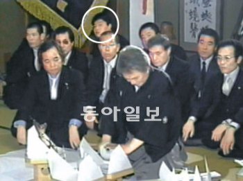 1988년 11월 14일 일본 오사카에서 열린 야쿠자 가네야마구미의 가네야마 고사부로 회장과 국내 칠성파 이강환 회장의 의형제 결연식에 참석한 강호동 씨(점선)가 의식을 지켜보고 있다. 채널A 제공