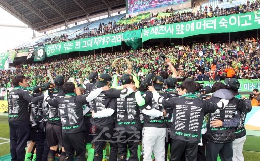 K리그 챔피언에 오른 전북 현대 선수들이 전북 응원단 앞에서 우승트로피를 든 채 어깨동무 춤을 추고 있다. 전주 ｜ 김종원 기자 won@donga.com 트위터 @beanjjun