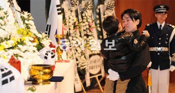 T-59 훈련기 추락 사고로 숨진 공군 조종사 박정수, 권성호 중령의 영결식에서 권 중령의 부인이자 전투기 조종사인 박지원 소령이 분향을 마친 뒤 아들을 안고 있다. 영결식은 7일 경북 예천군 제16전투비행단에서 엄수됐다. 공군 제공