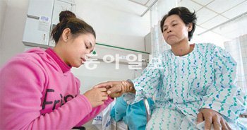 결혼이주여성인 립 셍힌 씨(왼쪽)가 병상의 어머니 테 수 씨와 대화를 나누고 있다. 테 수 씨는 한국 단체의 도움으로 한국에 와 경기 수원 아주대병원에서 갑상샘 낭종 수술을 받고 16일 건강하게 퇴원했다. 대한적십자사 경기도지사 제공