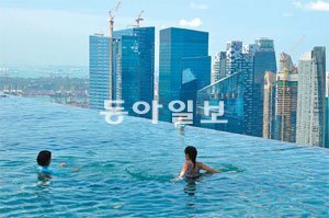 싱가포르의 럭셔리 리조트 ‘마리나베이샌즈’ 공중정원에 자리 잡은 수영장. 지상에서 200m 떨어진 호텔 옥상에 있어 스릴 만점의 재미를 준다. 싱가포르=이은택 기자 nabi@donga.com