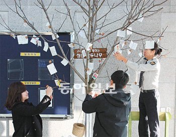 충남 천안시의 천안동남경찰서 현관에 설치된 ‘고래도 춤추게 하는 칭찬 호두나무’.직원들이 칭찬의 주인공과 추천 이유를 든 쪽지를 달고 있다. 천안동남경찰서 제공