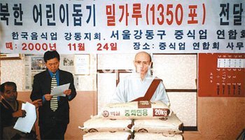 송월주 스님이 2000년 11월 북한 어린이를 돕기 위한 밀가루 전달 행사를 갖고 있다. 스님은 1995년부터 남북 불교계 교류와 대북 인도적 지원을 위해 노력해왔다. 송월주 스님 제공