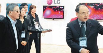 구본무 LG그룹 회장(왼쪽)이 6일 경기 고양시 일산서구 킨텍스에서 열린 ‘LG전자 한국마케팅본부 정책발표회’를 찾아 조택일 LG전자 TV상품기획그룹 상무(오른쪽)로부터 신제품 설명을 듣고 있다. LG그룹 제공