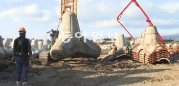 6일 제주 서귀포시 강정마을 제주해군기지 건설현장에서 한 인부가 크레인으로 방파제 공사에 쓰이는 테트라포드를 옮기고 있다. 서귀포=임재영 기자 jy788@donga.com