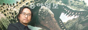 26일 개봉하는 영화 ‘점박이: 한반도의 공룡 3D’의 대형 포스터 앞에서 포즈를 취한 한상호 감독. 이 작품에는 80억 원이 투입됐으며 컴퓨터그래픽으로 만든 17종 80여 마리의 공룡 캐릭터가 등장한다. 최혁중 기자 sajinman@donga.com