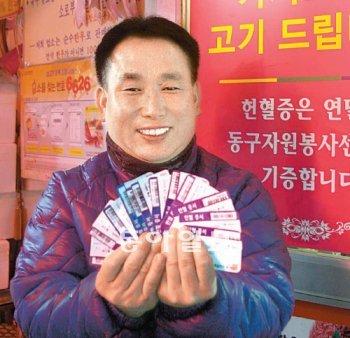 헌혈증서를 가지고 오면 돼지고기 한 근(9000원 상당)으로 바꿔주는 이태원 사장이 자신의 식육점에서 올해 들어온 헌혈증서를 든 채 환하게 웃고 있다. 노인호 기자 inho@donga.com