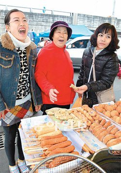 “속이 거시기헝께∼” 베트남에서 시집온 응우옌티투짱 씨(오른쪽)와 손아래 동서 함티베넛 씨(왼쪽)가 
설음식을 장만하려고 시어머니 김경란 씨와 함께 19일 전남 장성군 장성읍 시장을 찾았다. 튀김을 먹고 있는 고부간 표정이 시골 장
 풍경에 걸맞게 정겹다. 장성=박영철 기자 skyblue@donga.com