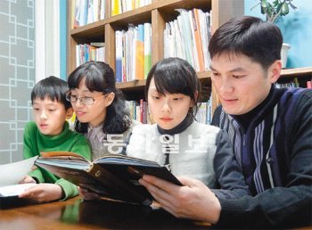 책을 읽으려고 책상 앞에 앉은 이나영 양 가족. 이 양은 10년 가까이 가족과 함께 독서 습관을 다지면서 지난해 본보와 
한우리독서문화운동본부가 공동 주최한 독서 올림피아드에서 대상을 받았다. 왼쪽부터 동생 준혁 군과 어머니 하욱이 씨, 나영 양, 
아버지 이재명 씨. 이나영 양 제공