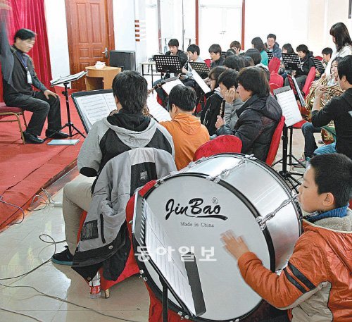 다롄 시에 하나뿐인 청소년오케스트라 ‘다롄 청소년 관악단’은 한국과 중국 학생들이 음악을 통해 교류하는 장이다. 이 관악단의 막내인 첸위안쩡 군(오른쪽)이 15일 열린 ‘경남필하모닉오케스트라와 함께하는 음악캠프’에서 북을 연주하고 있다. 첸 군은 “북을 익숙하게 치고 나면 다음번엔 드럼을 배워 보고 싶다”며 의욕을 보였다.