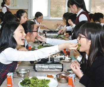 지난해 10월 전남 장성고 급식실에서 삼겹살 파티를 벌이고 있는 2학년 학생들. 상추쌈을 친구에게 먹여주는 모습이 정겹다. 장성고는 독특한 인성교육과 맞춤식 교육으로 흡연, 휴대전화, 왕따가 없는 ‘3무 학교’ 전통을 14년째 이어가고 있다. 장성고 제공