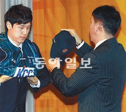 KCC 허재 감독(오른쪽)이 신인 드래프트에서 배구 스타 장윤창 씨의 아들인 장민국에게 유니폼과 모자를 건네고 있다. KBL 제공