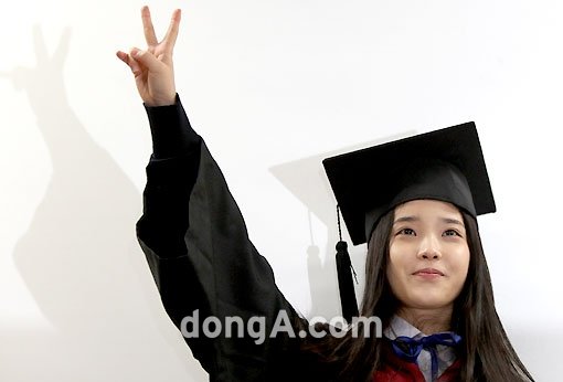 아이유가 9일 서울 동덕여고에서 졸업식을 마친 후 한 팔을 들어 올리며 V자를 그리고 있다. 국경원 기자 onecut@donga.com