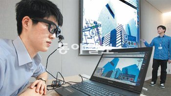 삼성전자 네트워크사업부 이상원 씨가 전신마비 환자들을 위해 개발한 안구마우스 ‘아이캔’을 쓰고 다음의 ‘로드뷰’ 화면을 시연하고 있다. 삼성전자 제공