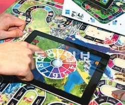 실제 회전판 대신 아이패드 터치스크린으로 휠을 돌려 보드게임을 하는 모습.