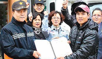 바다에 빠진 70대 노인을 구한 베트남 선원 잔티담 씨(오른쪽)가 강대중 목포소방서장
으로부터 명예소방관 위촉장을 받고 있다. 목포소방서 제공