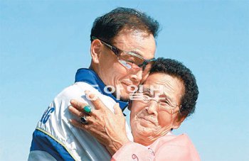 ‘봉달이’ 이봉주(왼쪽)가 마지막 레이스인 대전 전국체전 마라톤경기(2009년 10월)에서 우승한 뒤 어머니 공옥희 씨를 끌어안고 있다. 동아일보DB