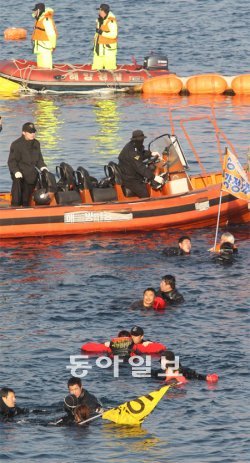 10일 오후 제주 서귀포시 강정항에서 시위대 10여 명이 잠수복과 구명조끼를 입은 채 바다로 뛰어들어 건설현장 침입을 시도하다 해경으로부터 저지당하고 있다. 서귀포=이훈구 기자 ufo@donga.com