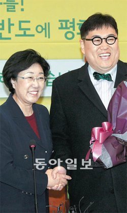 김용민 민주 입당 “2012년을 점령하겠다” 14일 인터넷 팟캐스트 ‘나는 꼼수다’ 멤버 김용민 씨(오른쪽)가 민주통합당에 입당했다. 이날 서울 노원갑 공천이 확정된 김 씨가 한명숙 대표로부터 환영 꽃다발을 받고 있다. 변영욱 기자 cut@donga.com