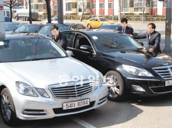 20일 서울 용산구 한강로의 현대자동차 중앙시승센터 앞에서 고객들이 영업사원의 설명을 들으며 현대차 제네시스(오른쪽)와 벤츠 E300(왼쪽)을 번갈아 살펴보고 있다. 홍진환 기자 jean@donga.com