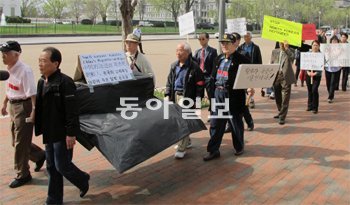 “中, 탈북자 북송 중단하라” 20일 미국 워싱턴 백악관 앞에서 중국의 탈북자 강제북송에 항의하는 시위대가 송환된 탈북자들이 처형될 수 있다는 것을 상징하는 뜻에서 ‘죽음의 관’을 들고 시위를 벌였다. 관광객들도 이들의 시위를 지켜보며 관심을 나타냈다. 워싱턴=정미경 특파원 mickey@donga.com