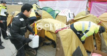 경찰이 22일 서울광장을 점거 중인 시위대의 텐트 및 천막에 대해 안전점검을 하며 휘발유나 가스 등 인화성 물질을 찾아내 수거하고 있다. 양회성 기자 yohan@donga.com