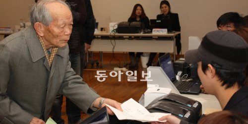 “이 서류로는 투표 안 된다고요?” 28일 일본 도쿄 주재 한국대사관에 설치된 투표소에서 이희팔 옹이 투표용지를 받기 위해 서류를 건네고 있다. 이 옹은 사전에 부재자 등록을 하지 않아 투표를 못한 채 발걸음을 돌렸다. 도쿄=김창원 특파원 changkim@donga.com