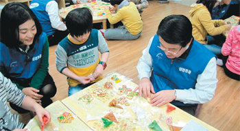 삼성증권은 매년 말에 봉사활동을 펼치는 나눔종무식을 진행하고 있다. 지난해 말 김석 사장(오른쪽)이 서울 중구 만리동 무지개지역아동센터에서 크리스마스 쿠키를 만드는 모습. 삼성증권 제공