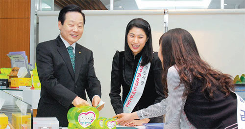 신종백 새마을금고중앙회장(왼쪽)이 올해 초 서울 강남구 삼성동에 위치한 세종새마을금고 지점을 찾아 ‘사랑의 좀도리 운동’ 금고에 기부를 하고 있다. 새마을금고중앙회 제공