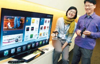 LG전자 정지윤 차장(왼쪽)과 조상현 책임연구원이 매직리모컨의 개발 스토리를 설명하며 웃고 있다. 이들은 “PC의 대중화를 이끈 마우스처럼 매직리모컨이 스마트TV의 대중화를 선도할 것”이라고 말했다. LG전자 제공