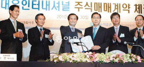 2010년 대우인터내셔널 매각 당시 한국자산관리공사의 이철휘 전 사장(왼쪽에서 세 번째)과 포스코 정준양 회장(오른쪽에서 세 번째)이 주식매매 계약을 체결하며 악수하고 있다. 한국자산관리공사 제공