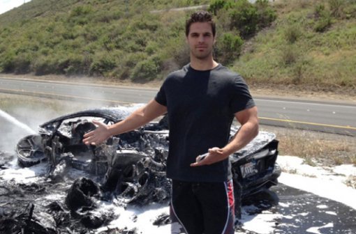 불에 탄 람보르기니 앞에서 익살맞은 포즈를 취하고 있는 운전자. 사진=motorward