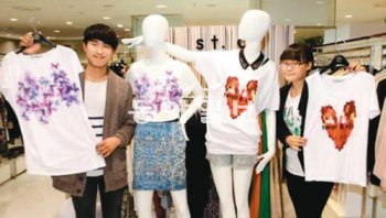 광주대 의상디자인학과 3학년 김광수 씨(왼쪽)와 손은하 씨가 광주신세계 의류 매장에서 자신들이 디자인한 반팔 티셔츠를 들어보이고 있다. 광주신세계 제공