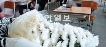 친구가 떠난 자리에 남겨진 조화(弔花)를 보며 급우들은 무슨 생각을 할까. 동급생에게 괴롭힘을 당해 16일 투신한 경북 영주 지역 중학생 이모 군의 교실 책상 위에 국화꽃이 올려져 있다. 영주=권기범 기자 kaki@donga.com