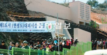 17일 인천 옹진군 연평면 연평초등학교 옆에 건립된 연평도 제1호 주민대피소 준공식에 참석한 주민들이 시설을 둘러보고 있다. 이날 연평도와 대청도에 북한의 포격에 대비한 주민대피소 16곳이 완공됐다. 옹진군청 제공