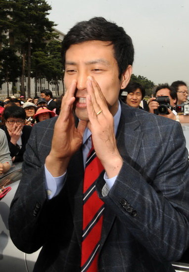 새누리당 문대성 부산 사하갑 당선자가 18일 국회를 빠져나가다 기자들에 막히자 승용차에서 나와 기자들의 질문에 답변하고 있다. (동아일보)