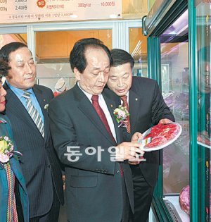 서규용 농림수산식품부 장관(가운데)이 19일 경기 성남시 상적동 소재 ‘농협안심 한우마을 청계산점(1호)’에서 제품 가격을 살펴보고 있다. 농협중앙회 제공