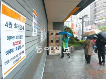 일부 시민들 헛걸음 대형마트 강제휴무를 본격적으로 실시한 첫날인 22일 서울 성북구 길음동 이마트에서 고객들이 철문에 붙은 휴점 안내문을 보고 발길을 돌리고 있다. 박영대 기자 sannae@donga.com