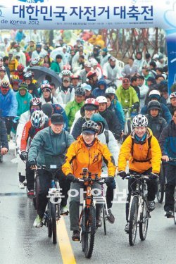 李대통령, 빗속 8km 자전거 질주 이명박 대통령(맨앞 가운데)이 22일 인천 서구 아라빛섬에서 열린 ‘제4회 대한민국 자전거 대축전’과 ‘투르 드 코리아 2012’ 개막식에 참석해 자전거를 타고 있다. 인천=양회성 기자 yohan@donga.com