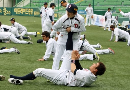 괜히 잘 나가는 게 아니다. 코칭스태프와 선수 간에, 선수와 선수 사이에 서로를 굳게 믿고 그라운드에서 하나로 뭉치고 있다. 두산 김현수(아래)가 1일 대구 삼성전 우천 취소에 앞서 트레이너의 도움 속에 몸을 풀며 웃고 있다. 사진제공｜스포츠코리아