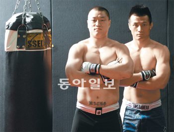 누가 ‘황소’이고 누가 ‘좀비’일까요 “같이 이기고 돌아오자.” 16일 미국 버지니아 주 페어팩스에서 열리는 종합격투기대회 ‘UFC ON FUEL TV’에 동반 출격하는 양동이(왼쪽)와 정찬성이 서울 영등포구 대림동에 있는 소속팀 코리안탑팀 체육관에서 포즈를 취했다. 사진 촬영을 위해 상의를 벗은 양동이는 “인상은 몰라도 피부는 내가 더 부드러운 것 같다”며 웃기도 했다. 양동이가 배꼽 밑에 ‘마초(MACHO)’라고 새겨 놓은 문신이 눈길을 끈다. 장승윤 기자 tomato99@donga.com