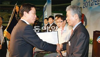 KS택시 김인남 대표(오른쪽)가 제23회 대구시 노사화합상을 받은 뒤 김범일 대구시장
과 악수를 하고 있다. 대구시 제공