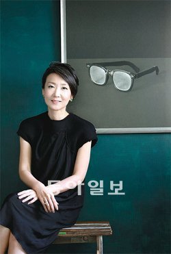 사진심리학자 신수진 교수가 자신의 작업실 한쪽에 마련한 ‘마음에 평화를 주는 벽’ 앞에서 포즈를 취했다. 깊은 숲을 떠올리게 하는 짙은 초록색 페인트를 벽에 직접 칠했고, 구본창 작가의 오래된 안경 사진을 걸었다. 신 교수는 벽 앞에 앉아 숲 속에서 책을 읽거나 누군가와 대화하는 상상을 즐긴다고 한다.